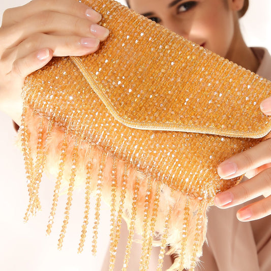 Woman holding a gold beaded clutch against a white background