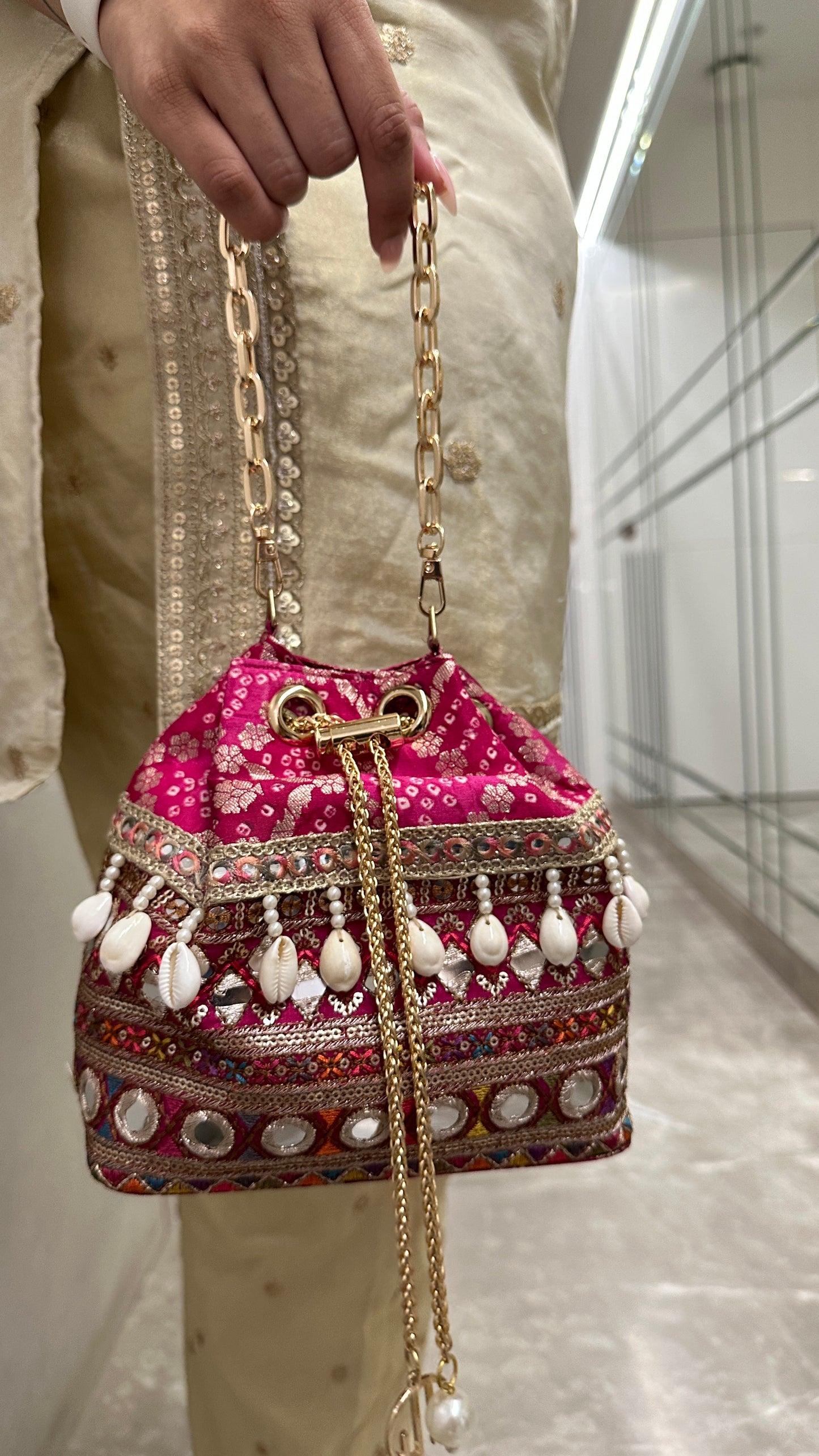 Rani Pink Bandhani Bucket Bag With Mirror Work And Natural Cowrie Shells