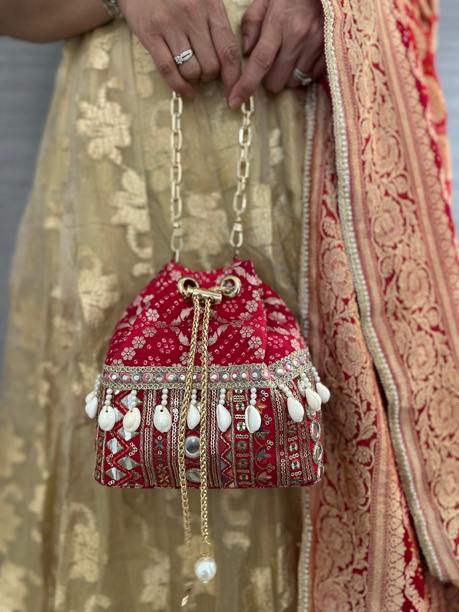 Rani Red Bandhani Bucket Bag with natural cowrie shells and mirror work zari lace